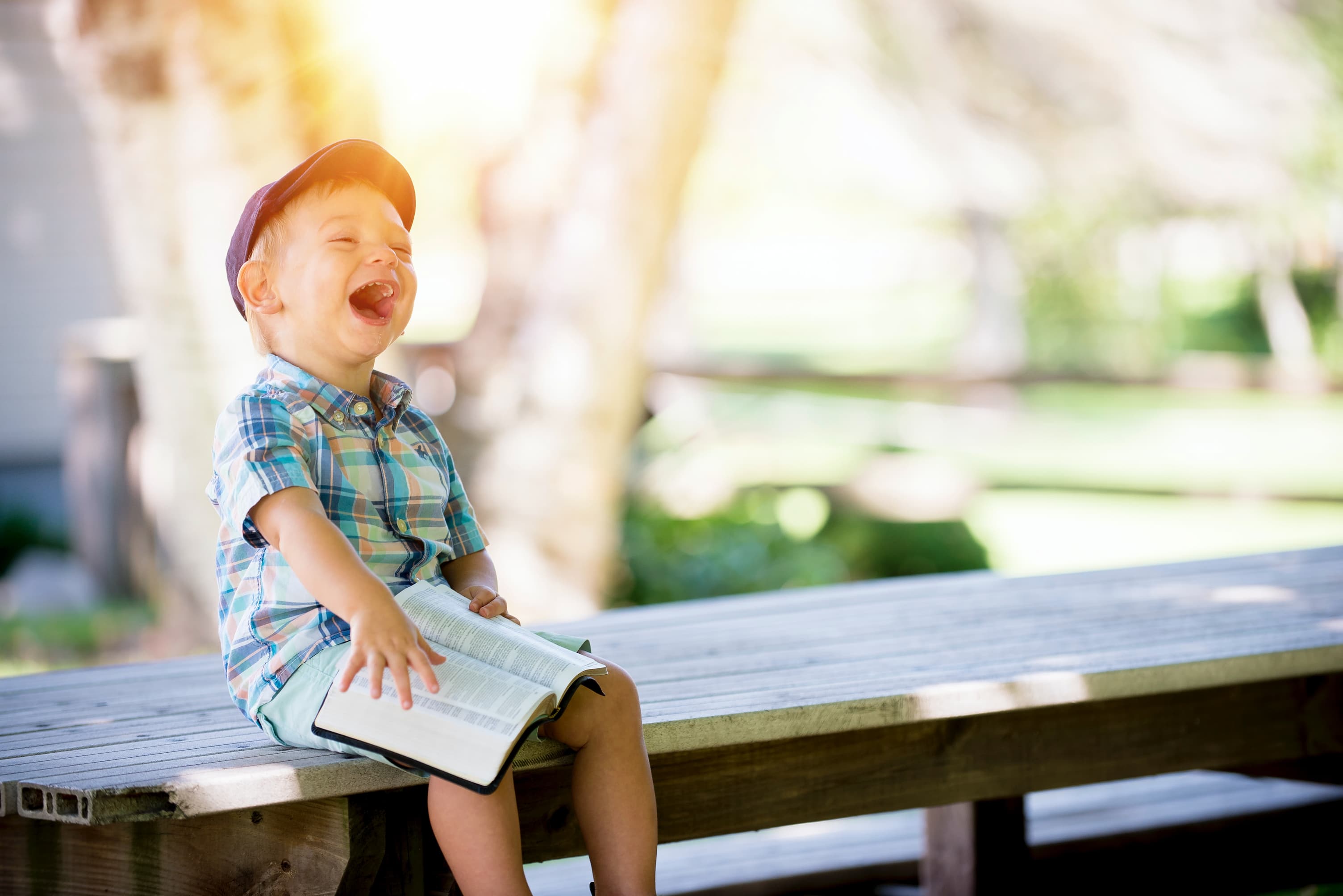 Child laughing while reading the Bible